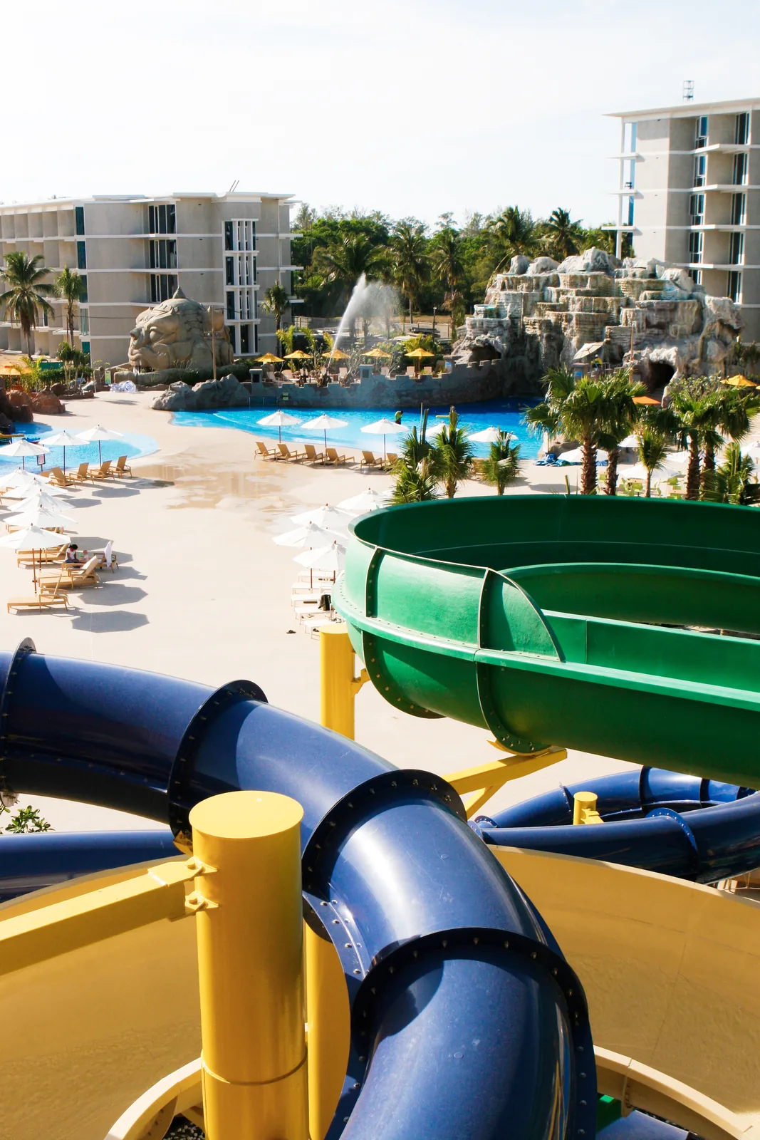 Water slides above a sunny resort pool