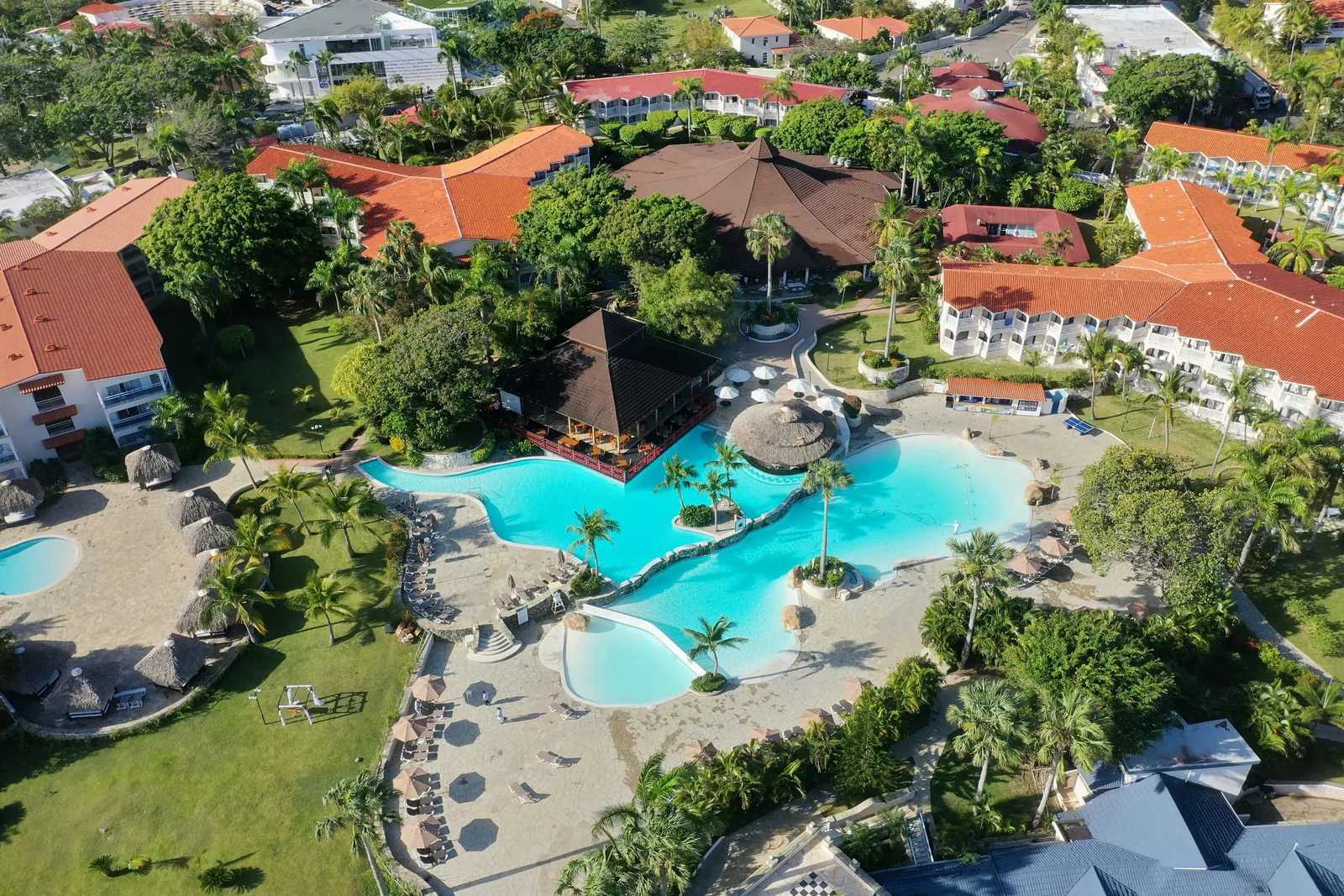Large tropical resort pool surrounded by palm trees