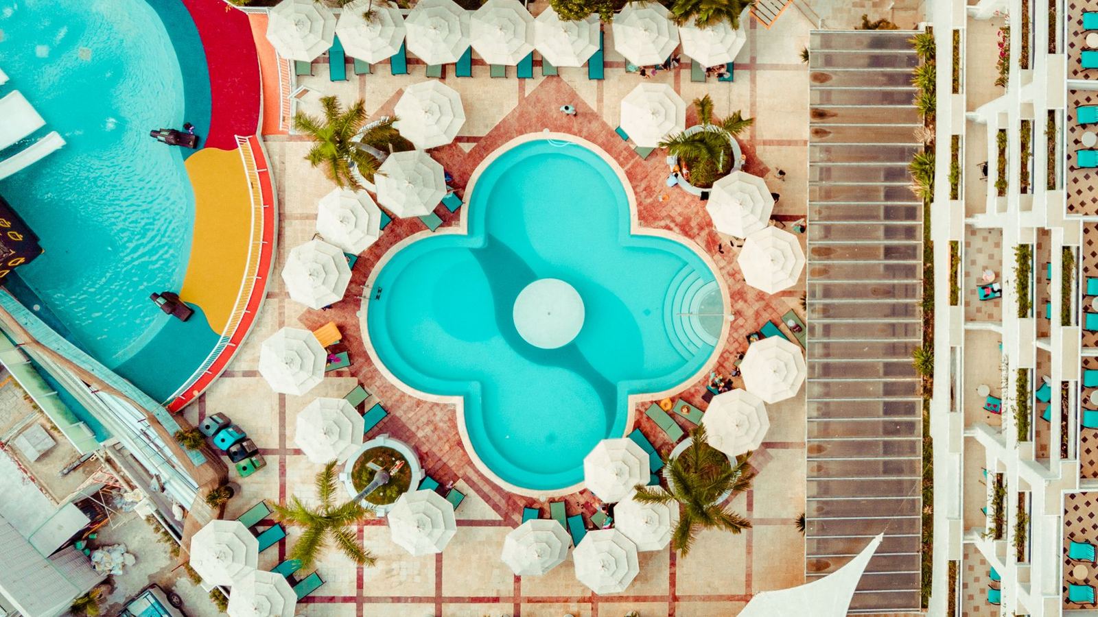 Stunning aerial photo of a colorful resort pool in Cancún, Mexico, showcasing vibrant design.
