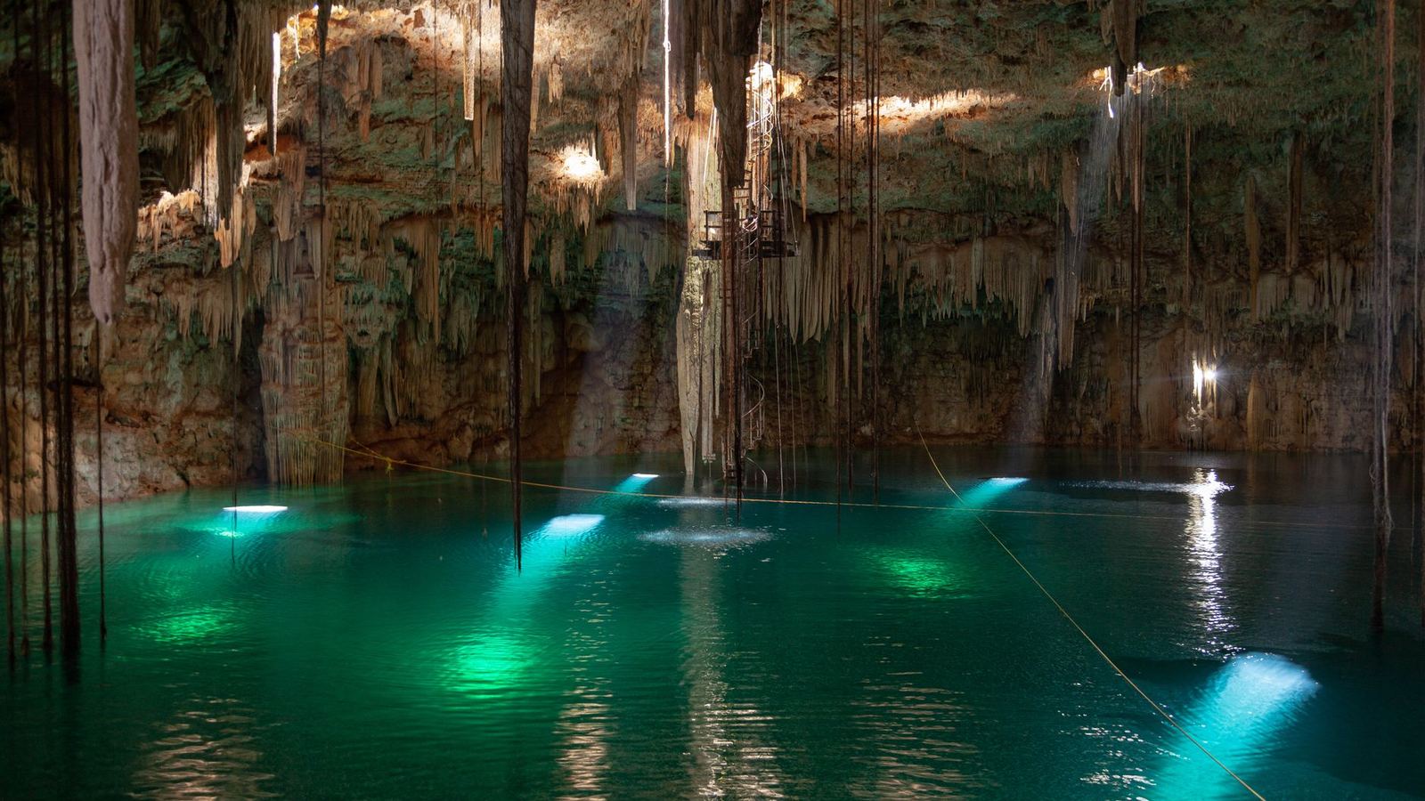 Spectacular cenote in Yucatán, Mexico with turquoise waters and stalactites.